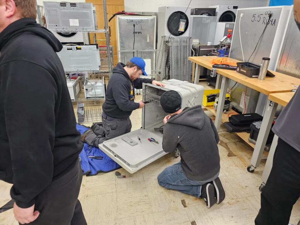 Oasis Appliance Works technician repairing a dishwasher in Dubai