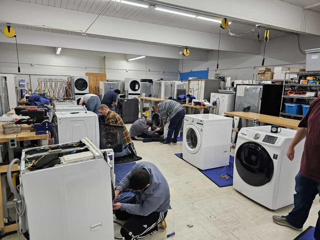 Oasis Appliance Works technician repairing a washing machine in Dubai